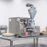 Formadora de salgados MCI sobre mesa inox. Ambiente industrial limpo e organizado.